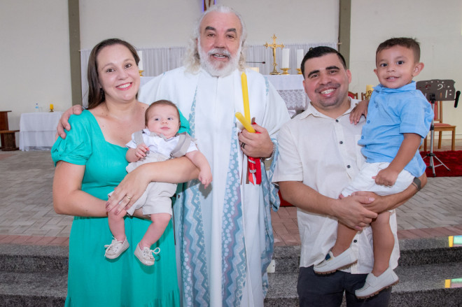 Luiz Felipe, em seu batizado, com Pe. Idonizete Krueger e seus pais Samuel e Josiane e o irmão Matheus